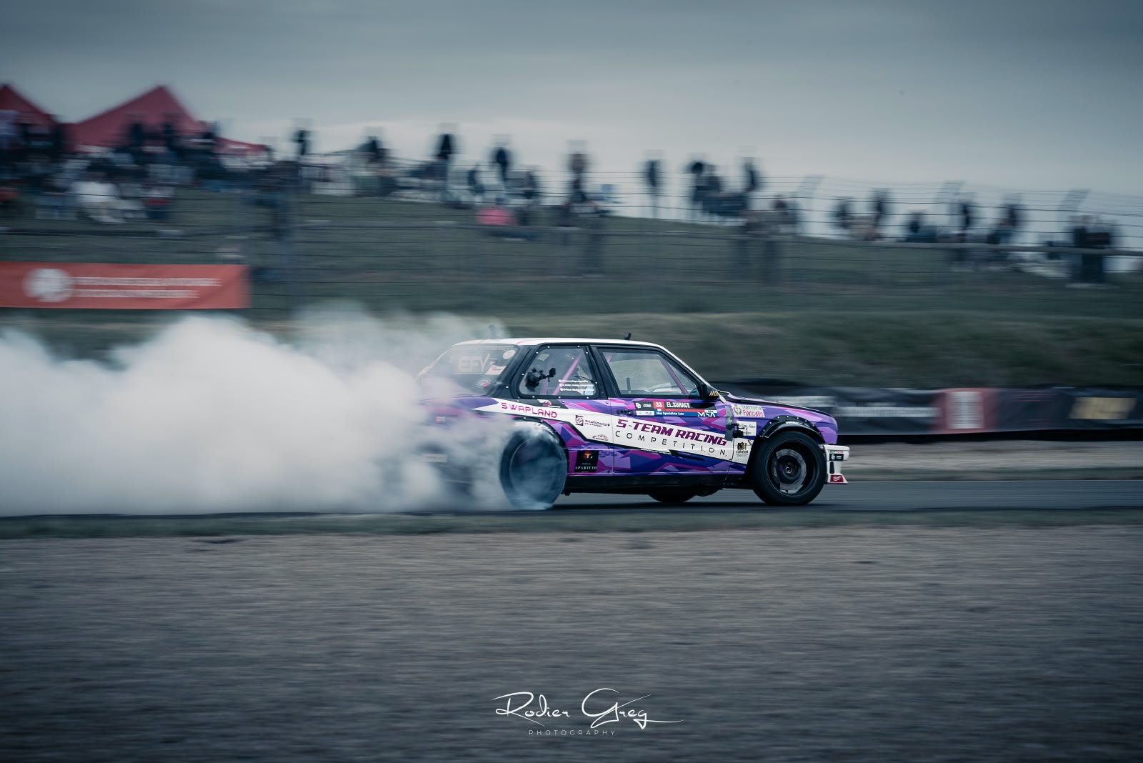 BMW E30 violette en drift devant les tribunes